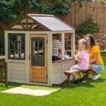 KidKraft Pioneer Cottage Wooden Playhouse – Outdoor Toy for Kids, Playhouse with Porch