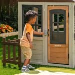 KidKraft Pioneer Cottage Wooden Playhouse – Outdoor Toy for Kids, Playhouse with Porch
